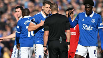 Everton's English defender #06 James Tarkowski (C) and Everton's Senegalese-born Belgian midfielder #08 Amadou Onana (R) remostrate with Referee Craig Pawson during the English Premier League football match between Liverpool and Everton at Anfield in Liverpool, north west England on October 21, 2023. (Photo by Paul ELLIS / AFP) / RESTRICTED TO EDITORIAL USE. No use with unauthorized audio, video, data, fixture lists, club/league logos or 'live' services. Online in-match use limited to 120 images. An additional 40 images may be used in extra time. No video emulation. Social media in-match use limited to 120 images. An additional 40 images may be used in extra time. No use in betting publications, games or single club/league/player publications. / (Photo by PAUL ELLIS/AFP via Getty Images)