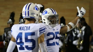 Oct 1, 2021; Logan, Utah, Brigham Young Cougars running back Tyler Allgeier (25) celebrates a touchdown with wide receiver Samson Nacua (45) against the Utah State Aggies at Merlin Olsen Field at Maverik Stadium. Mandatory Credit: Rob Gray-USA TODAY Sports