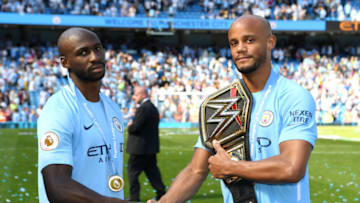 MANCHESTER, ENGLAND - MAY 06: Eliaquim Mangala of Manchester City and Yaya Toure of Manchester City shake hands on the pitch with a WWE belt after the Premier League match between Manchester City and Huddersfield Town at Etihad Stadium on May 6, 2018 in Manchester, England. (Photo by Michael Regan/Getty Images)
