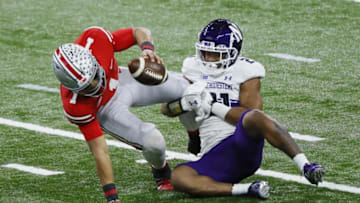 Northwestern Wildcats defensive back Cameron Mitchell (21) sacks Ohio State Buckeyes quarterback Justin Fields (1) during the first quarter of the Big Ten Championship football game at Lucas Oil Stadium in Indianapolis on Saturday, Dec. 19, 2020.Big Ten Championship Ohio State Northwestern