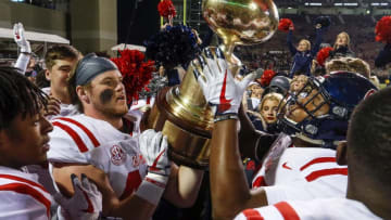 STARKVILLE, MS - NOVEMBER 23: Mississippi Rebels players celebrate by hoisting the Egg Bowl trophy after defeating the Mississippi State Bulldogs 31-28 in an NCAA football game at Davis Wade Stadium on November 23, 2017 in Starkville, Mississippi. (Photo by Butch Dill/Getty Images)