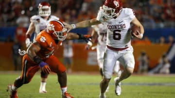Dec 31, 2015; Miami Gardens, FL, USA; Oklahoma Sooners quarterback Baker Mayfield (6) tries to stiff arm his way past Clemson Tigers defensive tackle D.J. Reader (48) in the third quarter of the 2015 CFP Semifinal at the Orange Bowl at Sun Life Stadium. Mandatory Credit: Kim Klement-USA TODAY Sports