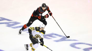 TORONTO, ONTARIO - AUGUST 15: Matt Grzelcyk #48 of the Boston Bruins is defended by Martin Necas #88 of the Carolina Hurricanes during the third period in Game Three of the Eastern Conference First Round during the 2020 NHL Stanley Cup Playoffs at Scotiabank Arena on August 15, 2020 in Toronto, Ontario. (Photo by Elsa/Getty Images)