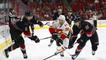 Jan 24, 2016; Raleigh, NC, USA; Calgary Flames forward Matt Stajan (18) can't get past the Carolina Hurricanes forward Elias Lindholm (16) and defensemen Noah Hanifin (5) during the third period at PNC Arena. The Carolina Hurricanes defeated the Calgary Flames 5-2. Mandatory Credit: James Guillory-USA TODAY Sports