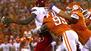 Oct 1, 2016; Clemson, SC, USA; Louisville Cardinals quarterback Lamar Jackson (8) is brought down by Clemson Tigers defensive end Clelin Ferrell (99) and defensive tackle Scott Pagano (56) during the first quarter at Clemson Memorial Stadium. Mandatory Credit: Joshua S. Kelly-USA TODAY Sports