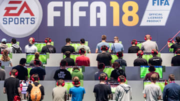 COLOGNE, GERMANY - AUGUST 22: Visitors play the soccer game FIFA18 while visiting the Gamescom 2017 video gaming trade fair on August 22, 2017 in Cologne, Germany. Gamescom is the world's second-largest games fair and attracts over 300,000 visitors. The 2017 fair will be open to the public from August 23-26. (Photo by Lukas Schulze/Getty Images)