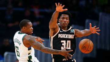 ATLANTA, GA - NOVEMBER 20: Eric Bledsoe #6 of the Milwaukee Bucks passes around Damian Jones #30 of the Atlanta Hawks during the first half of an NBA game at State Farm Arena on November 20, 2019 in Atlanta, Georgia. (Photo by Todd Kirkland/Getty Images)