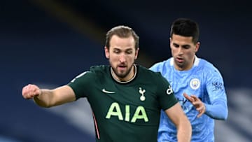 MANCHESTER, ENGLAND - FEBRUARY 13: Harry Kane of Tottenham Hotspur is closed down by Joao Cancelo of Manchester City during the Premier League match between Manchester City and Tottenham Hotspur at Etihad Stadium on February 13, 2021 in Manchester, England. Sporting stadiums around the UK remain under strict restrictions due to the Coronavirus Pandemic as Government social distancing laws prohibit fans inside venues resulting in games being played behind closed doors. (Photo by Shaun Botterill/Getty Images)