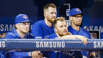 TORONTO, ONTARIO - JULY 28: Eric Sogard #5 of the Toronto Blue Jays stands behind teammates Danny Jansen #9, Billy McKinney #28, and Brandon Drury #3 during play against the Tampa Bay Rays in the third inning during their MLB game at the Rogers Centre on July 28, 2019 in Toronto, Canada. Sogard was traded to the Rays during the game. (Photo by Mark Blinch/Getty Images)