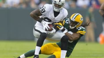 Aug 22, 2014; Green Bay, WI, USA; Oakland Raiders wide receiver James Jones (89) is tackled by Green Bay Packers cornerback Tramon Williams (38) after catching a pass during the first quarter at Lambeau Field. Mandatory Credit: Jeff Hanisch-USA TODAY Sports