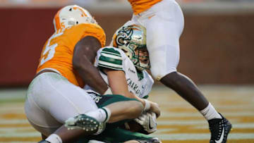 KNOXVILLE, TN - NOVEMBER 3: Evan Shirreffs #16 of the Charlotte 49ers hits his head on the leg of Defensive lineman Darrell Taylor #19 of the Tennessee Volunteers as he is being tackled by Defensive lineman Kyle Phillips #5 of the Tennessee Volunteers during the game between the Charlotte 49ers and the Tennessee Volunteers at Neyland Stadium on November 3, 2018 in Knoxville, Tennessee. Tennessee won the game 14-3. (Photo by Donald Page/Getty Images)