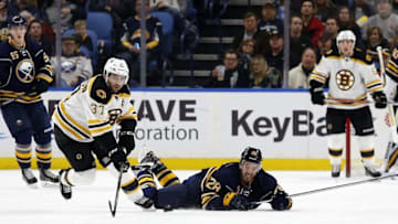 Dec 29, 2016; Buffalo, NY, USA; Buffalo Sabres center Zemgus Girgensons (28) dives to clear the puck away from Boston Bruins center Patrice Bergeron (37) during the second period at KeyBank Center. Mandatory Credit: Timothy T. Ludwig-USA TODAY Sports
