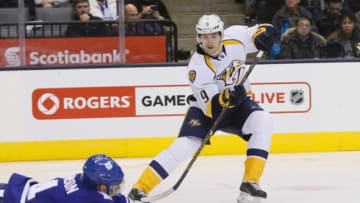 Nov 18, 2014; Toronto, Ontario, CAN; Nashville Predators forward Filip Forsberg (9) passes the puck past a diving Toronto Maple Leafs defenceman Cody Franson (4) during the first period at the Air Canada Centre. Mandatory Credit: John E. Sokolowski-USA TODAY Sports