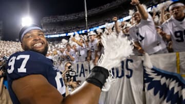STATE COLLEGE, PA - SEPTEMBER 18: PJ Mustipher #97 of the Penn State Nittany Lions celebrates with fans after the white out game against the Auburn Tigers at Beaver Stadium on September 18, 2021 in State College, Pennsylvania. (Photo by Scott Taetsch/Getty Images)