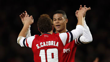 Arsenal's Spanish midfielder Santi Cazorla (L) celebrates scoring his goal with Arsenal's German midfielder Serge Gnabry during the English FA cup third round football match between Arsenal and Tottenham Hotspur at the Emirates Stadium in London on January 4, 2014. Arsenal won the game 2-0. AFP PHOTO/ADRIAN DENNISRESTRICTED TO EDITORIAL USE. No use with unauthorized audio, video, data, fixture lists, club/league logos or live services. Online in-match use limited to 45 images, no video emulation. No use in betting, games or single club/league/player publications. (Photo credit should read ADRIAN DENNIS/AFP via Getty Images)