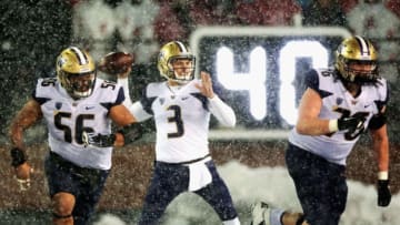 PULLMAN, WA - NOVEMBER 23: Quarterback Jake Browning #3 throws a pass while be defefended by Nick Harris #56 and Luke Wattenberg #76 of the Washington Huskies in the second half against the Washington State Cougars at Martin Stadium during the 111th Apple Cup on November 23, 2018 in Pullman, Washington. Washington defeated Washington State 28-15. (Photo by William Mancebo/Getty Images)