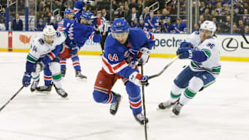 NEW YORK, NY - NOVEMBER 12: New York Rangers defenseman Neal Pionk (44) skates to loose puck as Vancouver Canucks center Markus Granlund (60) defends and Vancouver Canucks center Tyler Motte (64) tracks the play during the Vancouver Canucks and New York Rangers NHL game on November 12, 2018, at Madison Square Garden in New York, NY. (Photo by John Crouch/Icon Sportswire via Getty Images)