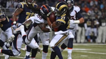 Nov 16, 2014; St. Louis, MO, USA; St. Louis Rams running back Tre Mason (27) breaks the tackle of Denver Broncos strong safety Quinton Carter (38) during the first half at the Edward Jones Dome. Mandatory Credit: Jasen Vinlove-USA TODAY Sports