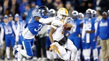 LEXINGTON, KY - OCTOBER 28: Jarrett Guarnanto of the Tennessee Volunteers runs with the ball while defended by Denzil Ware