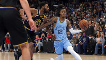 Jan 11, 2022; Memphis, Tennessee, USA; Memphis Grizzles guard Ja Morant (12) drives to the basket as Golden State Warriors forward Andrew Wiggins (22) defends during the second half at FedExForum. Mandatory Credit: Petre Thomas-USA TODAY Sports