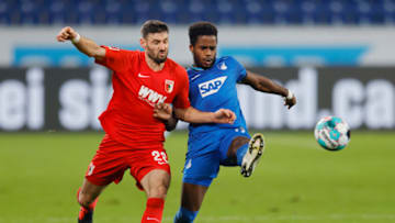 SINSHEIM, GERMANY - DECEMBER 07: Daniel Caligiuri (L) of Augsburg is challenged by Ryan Sessegnon of Hoffenheim during the Bundesliga match between TSG Hoffenheim and FC Augsburg. (Photo by Ronald Wittek - Pool/Getty Images)