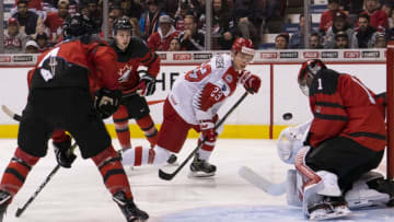 VANCOUVER, BC - DECEMBER 26: David Madsen #23 of Denmark shoots the puck on goalie Michael Dipietro #1 of Canada in Group A hockey action of the 2019 IIHF World Junior Championship action on December, 26, 2018 at Rogers Arena in Vancouver, British Columbia, Canada. Jared McIsaac #4 and Cody Glass #8 of Canada look on in the background. (Photo by Rich Lam/Getty Images)