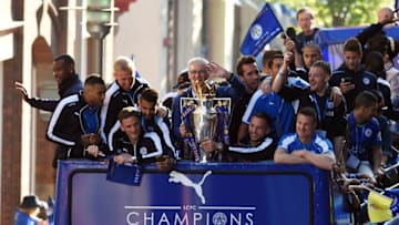 Leicester City's Italian manager Claudio Ranieri (C) holds the Premier league trophy as the Leicester City team take part in an open-top bus parade through Leicester to celebrate winning the Premier League title on May 16, 2016. / AFP / PAUL ELLIS (Photo credit should read PAUL ELLIS/AFP/Getty Images)