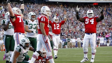 Oct 9, 2011; Foxboro, Massachusetts, USA; New England Patriots running back BenJarvus Green-Ellis (42) dives for a touchdown as quarterback Tom Brady (12), and guard Brian Waters (54) celebrate during the first quarter against the New York Jets at Gillette Stadium. Mandatory Credit: Greg M. Cooper-USA TODAY Sports