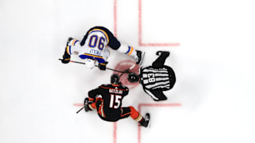 ANAHEIM, CALIFORNIA - MARCH 11: Ryan Getzlaf #15 of the Anaheim Ducks faces off with Ryan O'Reilly #90 of the St. Louis Blues as linesman Matt MacPherson #83 drops the puck during the second period of a game at Honda Center on March 11, 2020 in Anaheim, California. (Photo by Sean M. Haffey/Getty Images)
