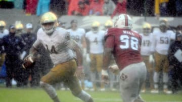 Oct 8, 2016; Raleigh, NC, USA; Notre Dame Fighting Irish quarterback DeShone Kizer (14) scrambles as North Carolina State Wolfpack defensive tackle B.J. Hill (98) pursues during the first half at Carter Finley Stadium. Mandatory Credit: Rob Kinnan-USA TODAY Sports