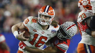 Clemson quarterback Trevor Lawrence, here being tackled by Ohio State cornerback Shaun Wade in the College Football Playoff Semifinal at the Fiesta Bowl in December, is part of a emerging collective of college football stars hoping to play this season.ghows_gallery_ei-OH-200819935-05257c21.jpg