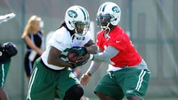Jul 24, 2014; Cortland, NY, USA; New York Jets quarterback Michael Vick (right) hands the ball off to running back Chris Johnson (left) during drills at training camp at SUNY Cortland. Mandatory Credit: Rich Barnes-USA TODAY Sports