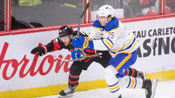 Jan 1,, 2023; Ottawa, Ontario, CAN; Ottawa Senators right wing Alex DeBrincat (12) and Buffalo Sabres defenseman Owen Power (25) battle in the third period at the Canadian Tire Centre. Mandatory Credit: Marc DesRosiers-USA TODAY Sports