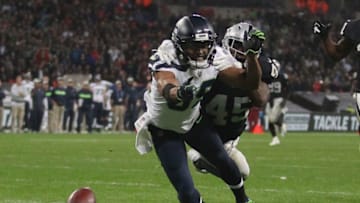 LONDON, ENGLAND - OCTOBER 14: Doug Baldwin of Seattle Seahawks attempts to catch a pass from the Seattle Seahawks quarterback while being tackled by Dominique Rodgers-Cromartie of Oakland Raiders during the NFL International series match between Seattle Seahawks and Oakland Raiders at Wembley Stadium on October 14, 2018 in London, England. (Photo by James Chance/Getty Images)