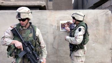 RAMADI, IRAQ - JANUARY 21: U.S. Army Sergeant Christopher Miller from Syracuse, New York (L) and Specialist John Grieger from Mundeleil, Illinois of the 1st Battalion, 503rd Infantry Regiment place a poster on a wall that encourages Iraqis to vote in the upcoming elections January 21, 2005 in Ramadi, Iraq. The U.S. military is helping to get the word out for people to turn out and vote as well as trying to stabilize the city so people can vote safely on January 30. (Photo by Joe Raedle/Getty Images)