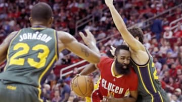 Jan 7, 2016; Houston, TX, USA; Houston Rockets guard James Harden (13) drives as he splits the defense of Utah Jazz forward Chris Johnson (23) and guard Raul Neto (25) in the second half at Toyota Center. Rockets won 103 to 94. Mandatory Credit: Thomas B. Shea-USA TODAY Sports