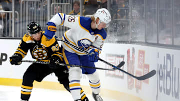 BOSTON, MASSACHUSETTS - APRIL 28: Brad Marchand #63 of the Boston Bruins and Rasmus Dahlin #26 of the Buffalo Sabres battles for control of the puck during the first period at TD Garden on April 28, 2022 in Boston, Massachusetts. (Photo by Maddie Meyer/Getty Images)