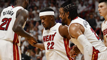 Miami Heat forward Jimmy Butler (22) is helped up after a play by center Dewayne Dedmon (21) and guard Gabe Vincent (2)(Jim Rassol-USA TODAY Sports)