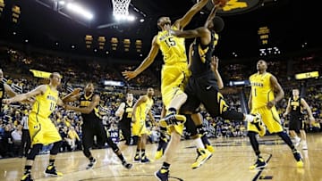 Jan 22, 2014; Ann Arbor, MI, USA; Michigan Wolverines forward Jon Horford (15) blocks a shot by Iowa Hawkeyes guard Roy Devyn Marble (4) in the second half at Crisler Arena. Michigan won 75-67. Mandatory Credit: Rick Osentoski-USA TODAY Sports