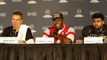 Jan 12, 2015; Arlington, TX, USA; Ohio State Buckeyes head coach Urban Meyer, quarterback Cardale Jones (12) and running back Ezekiel Elliott (15) during a press conference after beating the Oregon Ducks in the 2015 CFP National Championship Game at AT&T Stadium. Mandatory Credit: Tim Heitman-USA TODAY Sports