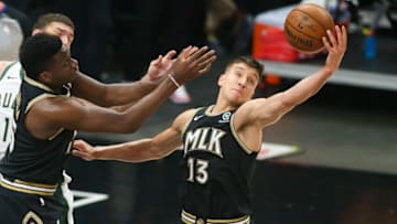 Jun 29, 2021; Atlanta, Georgia, USA; Atlanta Hawks guard Bogdan Bogdanovic (13) grabs a rebound past center Clint Capela (15) against the Milwaukee Bucks in the first quarter during game four of the Eastern Conference Finals for the 2021 NBA Playoffs at State Farm Arena. Mandatory Credit: Brett Davis-USA TODAY Sports