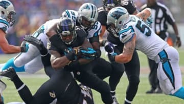 Sep 28, 2014; Baltimore, MD, USA; Baltimore Ravens running back Lorenzo Taliaferro (34) carries the ball as Carolina Panthers tackle Kawann Short (99) tackles at M&T Bank Stadium. Mandatory Credit: Mitch Stringer-USA TODAY Sports