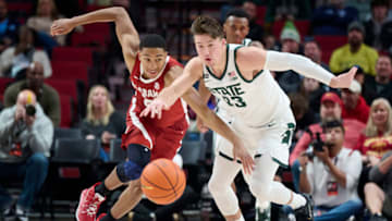Nov 24, 2022; Portland, Oregon, USA; Alabama Crimson Tide guard Nimari Burnett (25) and Michigan State Spartans guard Jason Whitens (43) race after the basketball during the first half at Moda Center. Mandatory Credit: Troy Wayrynen-USA TODAY Sports