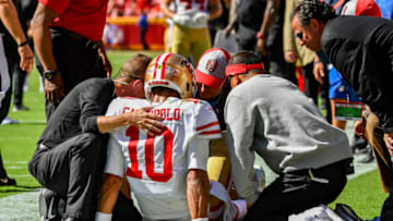 KANSAS CITY, MO - SEPTEMBER 23: Head coach Kyle Shanahan of the San Francisco 49ers and the team training staff examine quarterback Jimmy Garoppolo #10 on the sideline after being hurt on a play during the fourth quarter of the game against the Kansas City Chiefs at Arrowhead Stadium on September 23rd, 2018 in Kansas City, Missouri. (Photo by Peter Aiken/Getty Images)