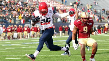 Dec 31, 2013; Shreveport, LA, USA; Arizona Wildcats running back Ka'Deem Carey (25) carries the ball into the end zone for a touchdown in front of Boston College Eagles defensive back Dominique Williams (9) in the third quarter at Independence Stadium. Arizona defeated Boston College 42-19. Mandatory Credit: Crystal LoGiudice-USA TODAY Sports