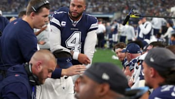 ARLINGTON, TEXAS - DECEMBER 15: Offensive coordinator Kellen Moore of the Dallas Cowboys talks with Dak Prescott #4 of the Dallas Cowboys on the sidelines as the Cowboys take on the Los Angeles Rams at AT&T Stadium on December 15, 2019 in Arlington, Texas. (Photo by Tom Pennington/Getty Images)