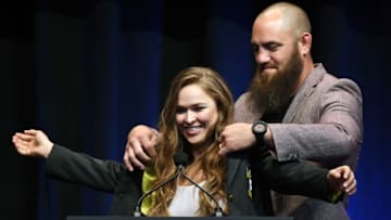 LAS VEGAS, NV - JULY 05: Mixed martial artist Travis Browne (R) puts a UFC Hall of Fame jacket on his wife Ronda Rousey after she became the first female inducted into the UFC Hall of Fame at The Pearl concert theater at Palms Casino Resort on July 5, 2018 in Las Vegas, Nevada. (Photo by Ethan Miller/Getty Images)