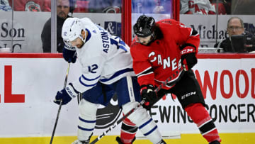 RALEIGH, NORTH CAROLINA - NOVEMBER 06: Zach Aston-Reese #12 of the Toronto Maple Leafs battles Jalen Chatfield #5 of the Carolina Hurricanes for the puck during the second period of their game at PNC Arena on November 06, 2022 in Raleigh, North Carolina. (Photo by Grant Halverson/Getty Images)