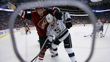 Feb 2, 2016; Glendale, AZ, USA; Arizona Coyotes defenseman Michael Stone (26) checks Los Angeles Kings right wing Dustin Brown (23) during the third period at Gila River Arena. The Kings won 6-2. Mandatory Credit: Joe Camporeale-USA TODAY Sports