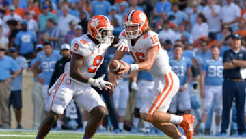 CHAPEL HILL, NORTH CAROLINA - SEPTEMBER 28: Trevor Lawrence #16 hands off to Travis Etienne #9 of the Clemson Tigers during their game against the North Carolina Tar Heels at Kenan Stadium on September 28, 2019 in Chapel Hill, North Carolina. Clemson won 21-20. (Photo by Grant Halverson/Getty Images)